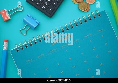 Calendar and office supplies on a blue table in January Stock Photo