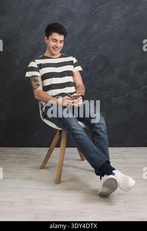 Handsome man using smartphone in studio Stock Photo