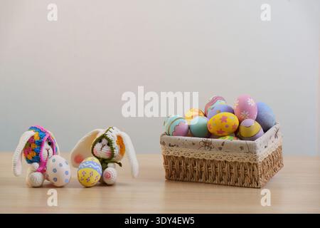Easter Fun. Two bunnies with colorful eggs in a woven basket. Stock Photo