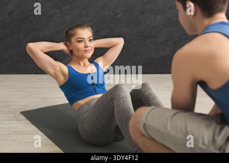 Fitness coach help with doing crunches Stock Photo