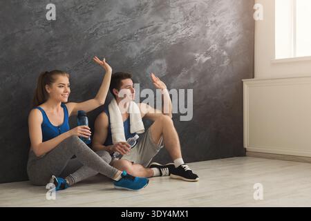 Fitness couple drinking water at gym Stock Photo