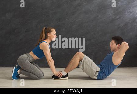 Fitness coach help with doing crunches Stock Photo