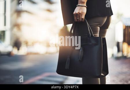 Bag, city and hand of business woman on sidewalk for commute to work location in morning. Flare, street and waiting with professional employee outdoor Stock Photo
