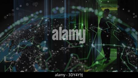 Holding tablet tech dark-clad scanning holographic globe by rack LEDs in server aisle, copy space Stock Photo