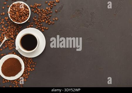 Cup of black coffee and scattered beans on gray background Stock Photo