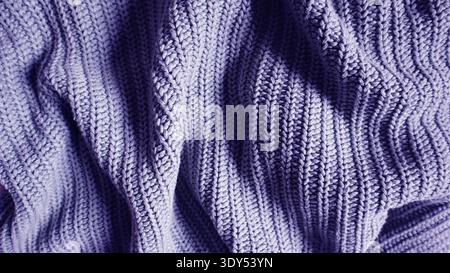 Knitted wool fabric texture in lavender purple color. Close-up shot of ribbed yarn pattern with natural folds. Minimalist textile background for winte Stock Photo