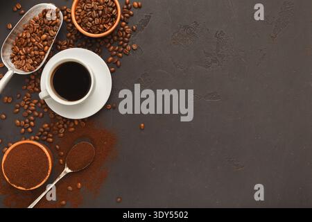 Cup of black coffee and scattered beans on gray background Stock Photo