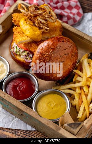 Crispy chicken burger with fries and sauces Stock Photo