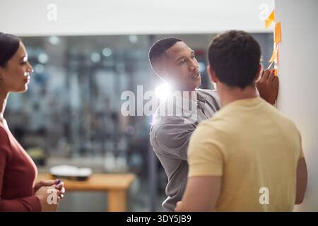 Meeting, team and sticky note with business people in office for feedback, discussion and event organizer. Creative pitch, expo project and Stock Photo