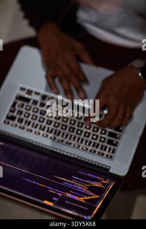 Hands, hacker and laptop screen with code in home for ransomware, phishing and browser hijacking. Above, tech display and person with cybercrime on Stock Photo