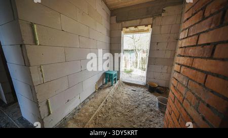 Interior room of a house under construction with building materials and brick walls Stock Photo