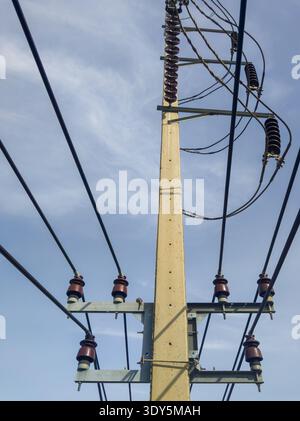 Concrete electric pole with ceramic insulators and voltage lines, in ...