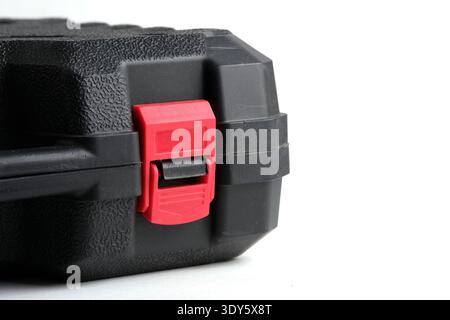 Red plastic latch on black tool case. Close up protective storage box for equipment and safe transportation Stock Photo