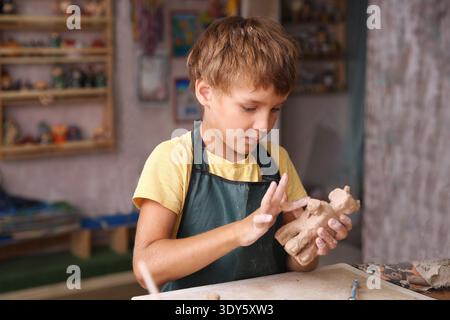 Kids molded from clay at pottery class. || Model released Stock Photo
