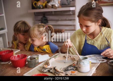 Kids molded from clay at pottery class. || Model released Stock Photo