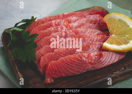 Chum salmon, cold smoked, sliced, on a cutting board, with lemon and parsley, top view, close-up, no people Stock Photo