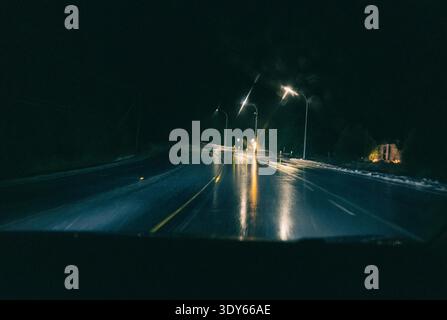 POV driving down highway at night with blur from rain and motion Stock Photo
