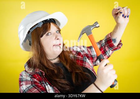 Woman preparing to work holding hammer and nails Stock Photo