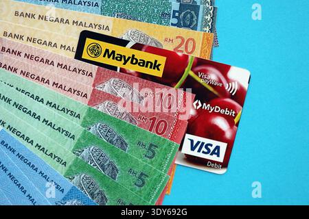 KYIV, UKRAINE - JANUARY 28, 2026 Maybank card and Malaysian ringgit money bills on table close up. Maybank is most popular bank in Malaysia Stock Photo