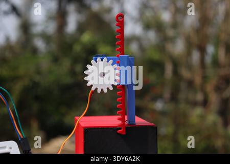 3D printed gear and slider mechanism printed with different color pla filaments connected to a servo motor Stock Photo