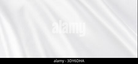White soft luxury silk fabric creating flowing, undulating folds and ripples Stock Photo