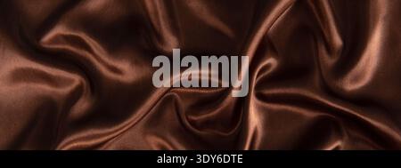Brown silk fabric creating a smooth, flowing, luxurious texture background Stock Photo