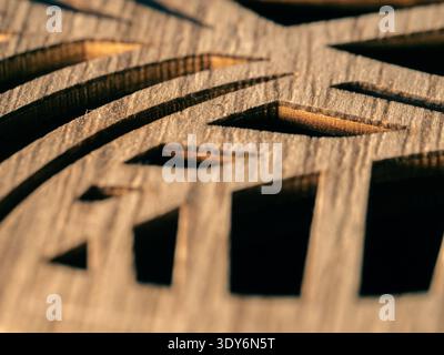 Wood grain shows intricate carved patterns. Light highlights texture and depth in each cut. Geometric shapes form a rhythmic, artistic design. Natural Stock Photo