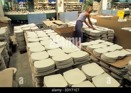 Workers sort earthenware plates in a factory in Lorraine region of France during the day Stock Photo