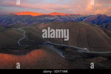 Winding road through the hills under a sunset sky in Serrania de Hornocal, Humahuaca, Jujuy, Argentina Stock Photo