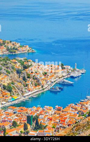 High angle view of Gialos harbour on Symi Island with colorful buildings and boats on clear blue water Stock Photo