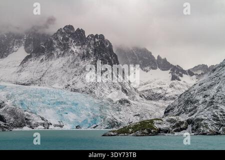 Snowstorm brings cold and wind to Larsen Harbour in Drygalski Fjord on South Georgia Island in the Southern Ocean during winter months Stock Photo