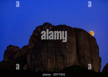 Full moon rises over rock formations at Meteora in Thessaly Greece during the night sky Stock Photo