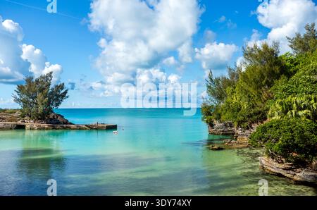Clear water and cloud reflections near shore at a beach in a tropical park setting in Bermuda on a bright day Stock Photo