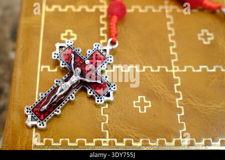 Old holy bible with leather cover and rosary shows crucifixion scene in Warsaw, Poland Stock Photo