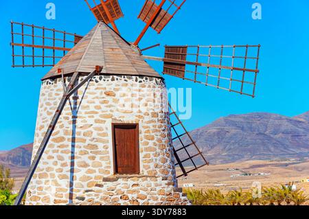 Traditional windmill in Fuerteventura surrounded by clear sky and mountains in Canary Islands Stock Photo