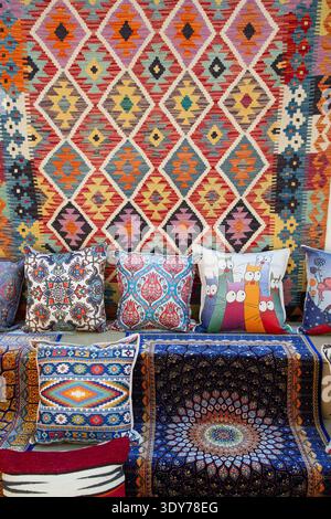 Explore rich carpets and colorful pillows for sale in Kaleici market in Antalya Province, Turkey on a sunny day Stock Photo