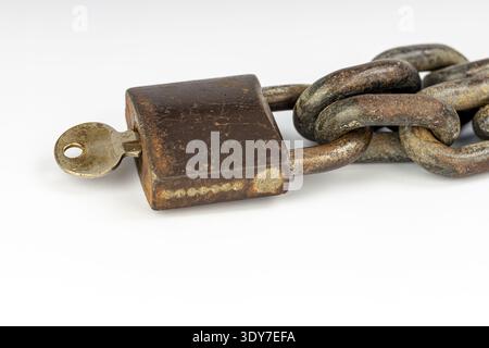 An old padlock metal chain rusty lock antique key security concept vintage metal corrosion texture protection symbol white background closeup detail a Stock Photo