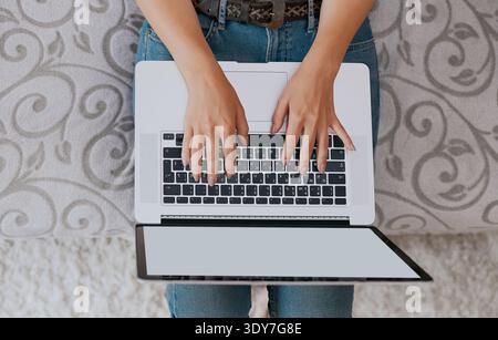 Woman working on laptop and writing, top view Stock Photo