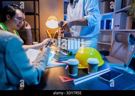 Engineers and architects analyze construction models and discuss project strategies, combining technical knowledge and creative ideas to achieve succe Stock Photo