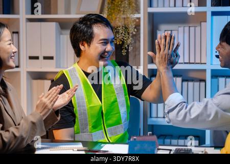 A team of architects and engineers coordinates on an architectural project, reviewing design concepts and technical plans to ensure efficiency and cre Stock Photo