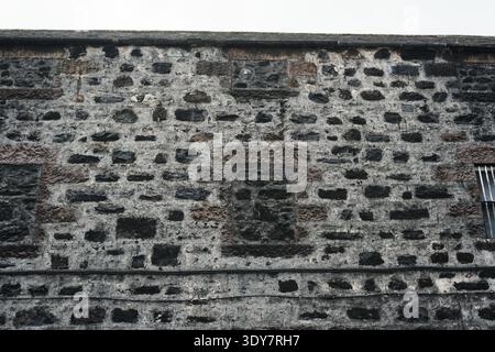 Blackened stone warehouse walls and bricked over windows at Glenfarclas Distillery, Ballindalloch, Speyside, Scotland Stock Photo