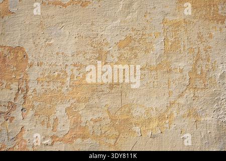 Yellow ochre plaster wall texture with rough weathered stucco and scratches Stock Photo
