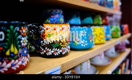Colorful Hand Painted Ceramic Cups on Wooden Shelf Stock Photo