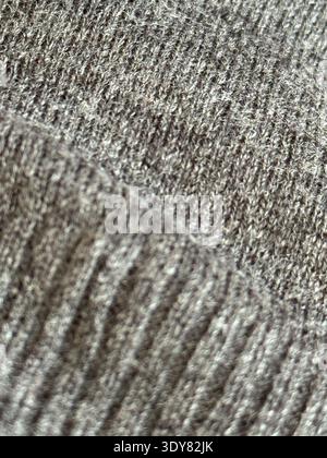 Close-up texture of gray knitted fabric showing detailed patterns, ideal for textile background. Mobile photo Stock Photo