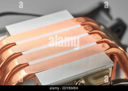 computer tower cpu cooler base with exposed copper heat pipes, integrated into silver metal block, closeup soft focus, pc cooling technology concept Stock Photo
