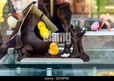 Mona de Pascua, a typical Easter cake eaten in Spain on Easter Monday, decorated with a chocolate egg, a plush chick and feathers of different colors. Stock Photo