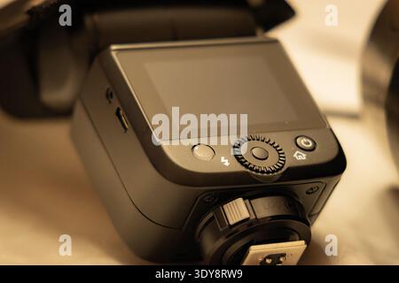 Professional wireless camera flash trigger with LCD screen and control dial, close-up on hot shoe mount and buttons. Stock Photo
