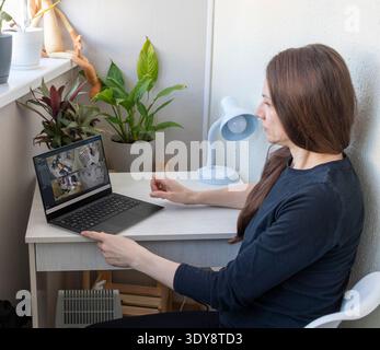 Woman monitors footage from cctv cameras on his laptop Stock Photo
