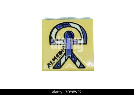Yellow square ceramic tile with blue abstract emblem and the word 'almeria' handwritten, glossy finish Stock Photo