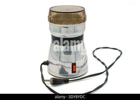 Vintage electric coffee grinder on white background. Chrome body with black band, brown translucent lid, power cord and plug, red switch. Isolated pro Stock Photo